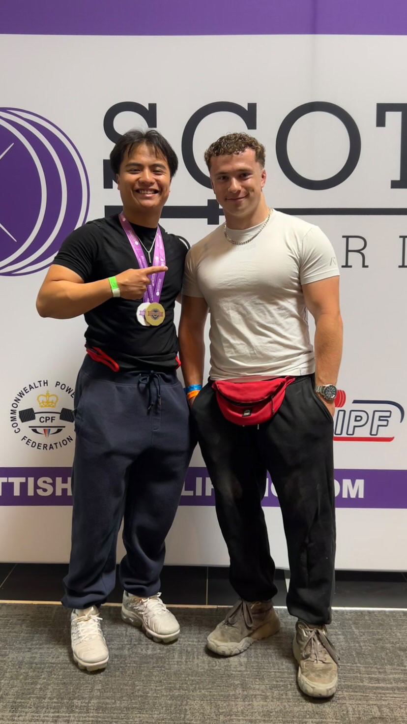 A medal-winning lifter with his coach at a Scottish Powerlifting championship