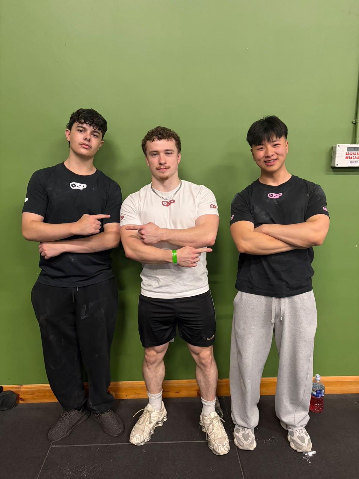 Coach with two lifters wearing Overshooter Performance T-shirts